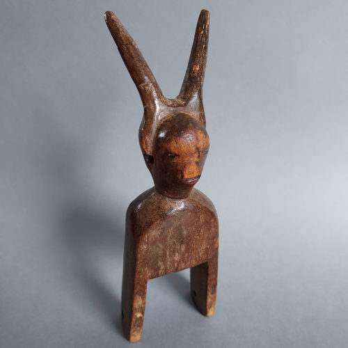 jimini or djimini wood heddle pulley with horned figure from ivory coast