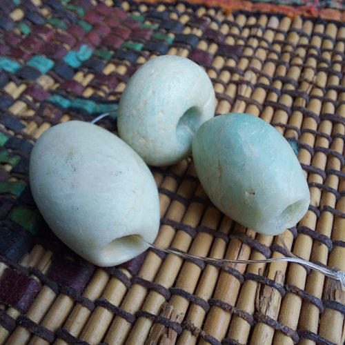 three excavated ancient amazonite stone beads of different shapes from the sahara desert in niger