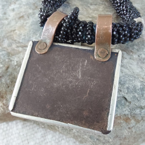 Ethnic necklace with brass and silver pendants.