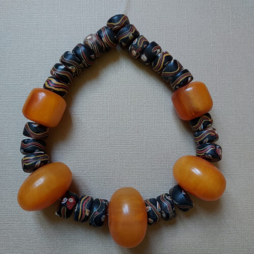 Colourful strand of antique Venetian tire shape trade beads with eyes and old phenolic amber beads.