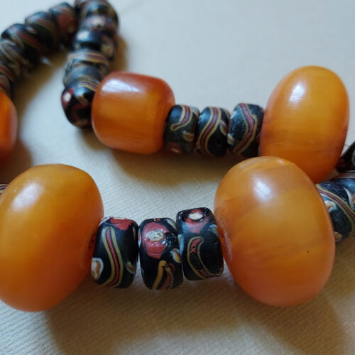 Colourful strand of antique Venetian tire shape trade beads with eyes and old phenolic amber beads.