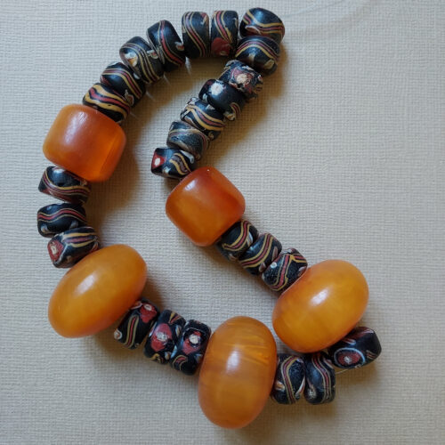 Colourful strand of antique Venetian tire shape trade beads with eyes and old phenolic amber beads.