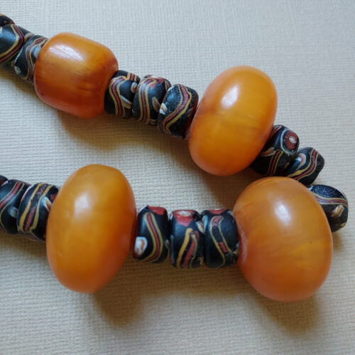 Colourful strand of antique Venetian tire shape trade beads with eyes and old phenolic amber beads.