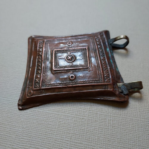 Tuareg tcherot amulet made of copper with a fine repoussé pattern from Niger.