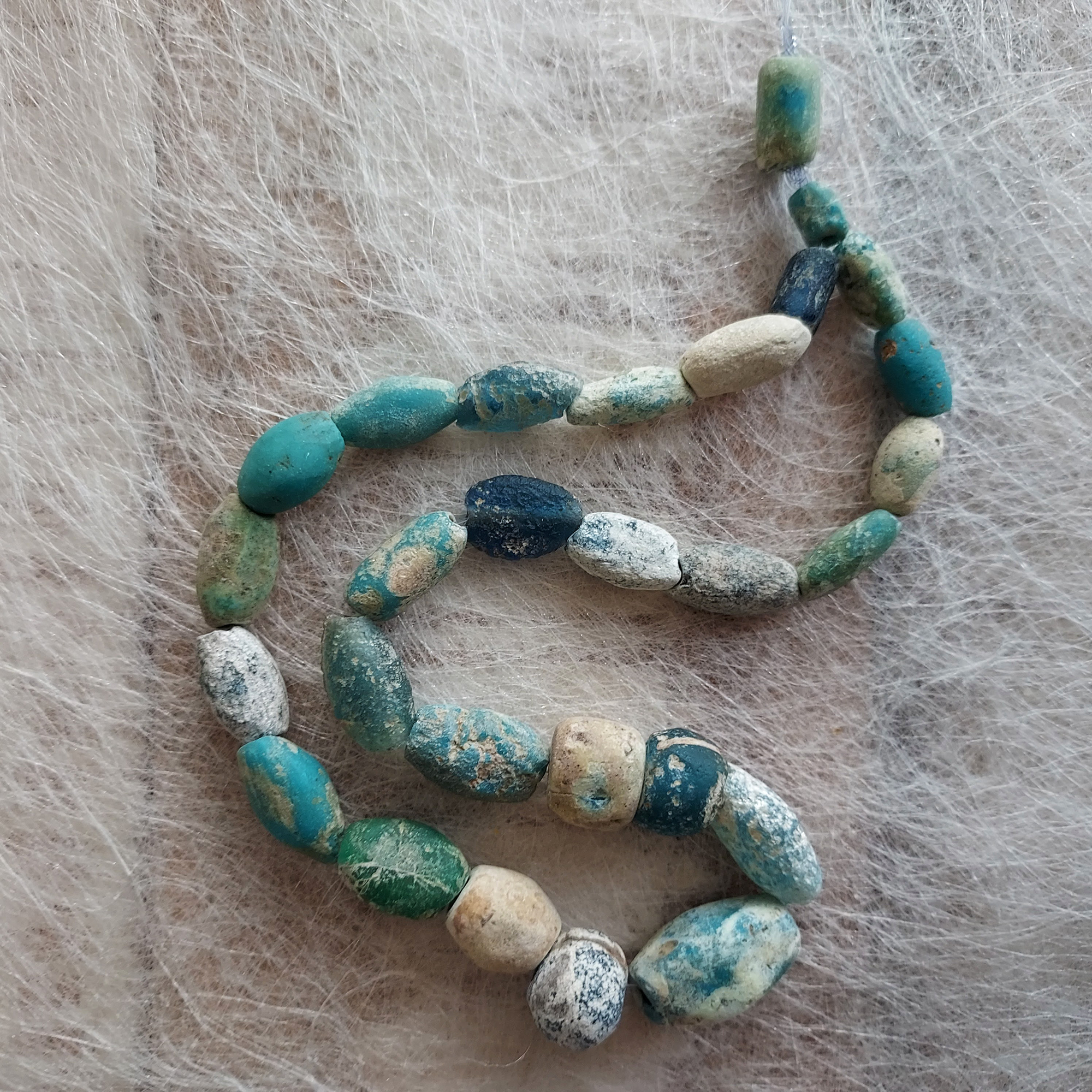Ancient glass beads in turquoise, blue and green colours