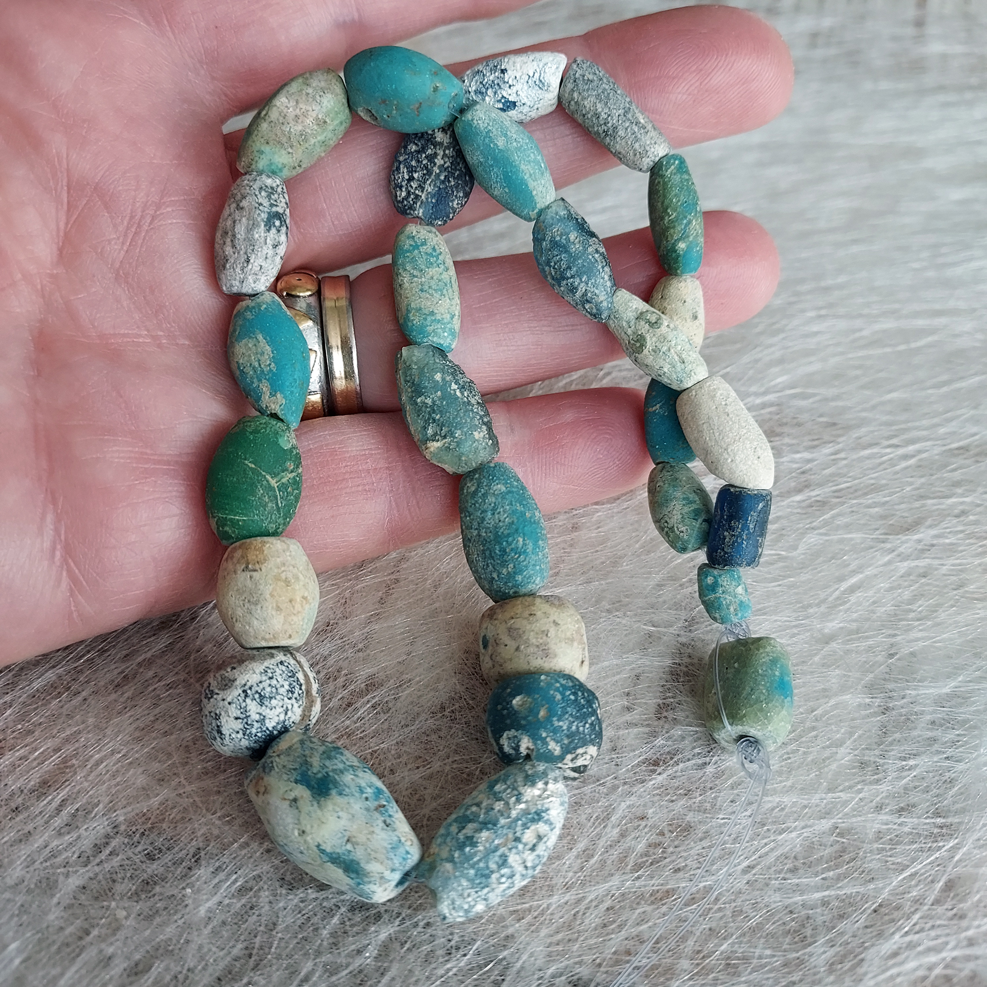 Ancient glass beads in turquoise, blue and green colours