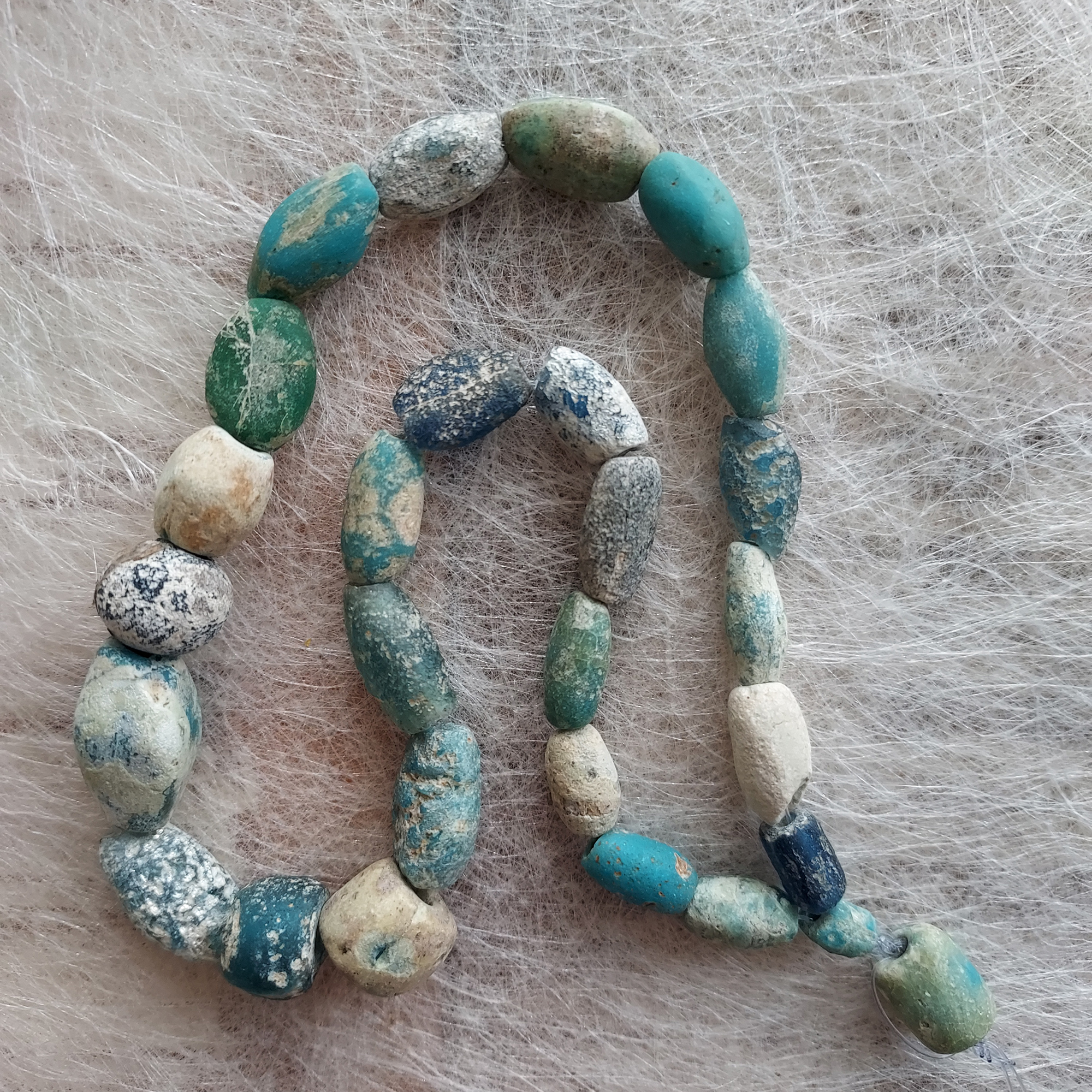 Ancient glass beads in turquoise, blue and green colours